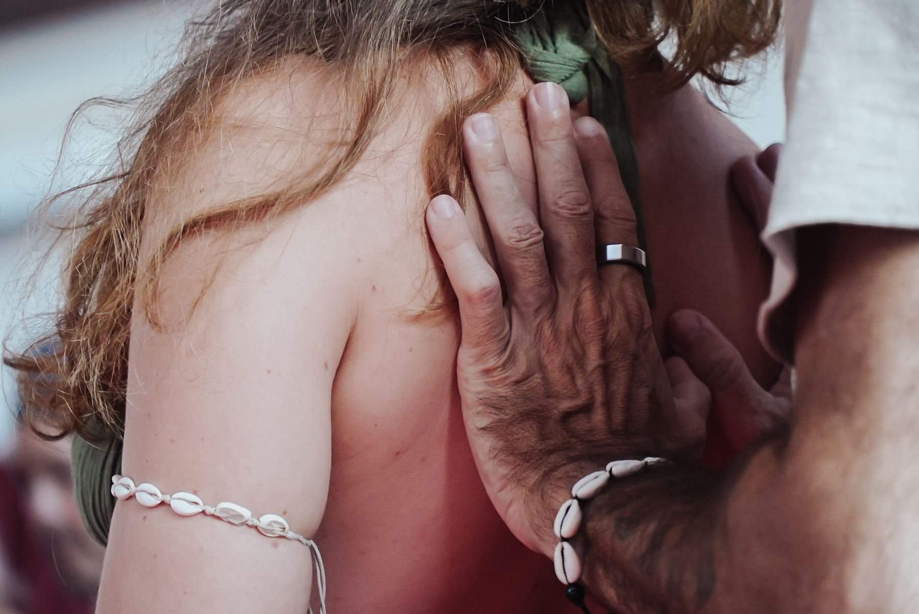 A hand resting on a bare shoulder.